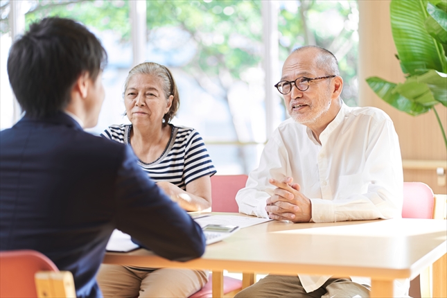 老夫婦が若い青年に相談をしている写真 老夫婦が若い青年に相談をしている写真