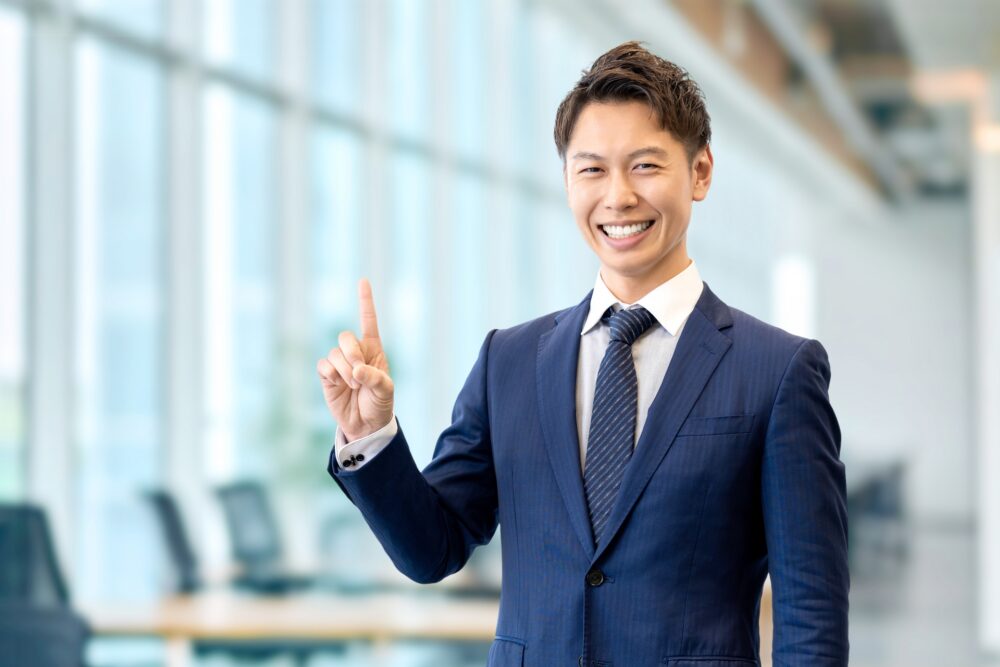 人差し指を立てている営業マン 人差し指を立てている営業マン